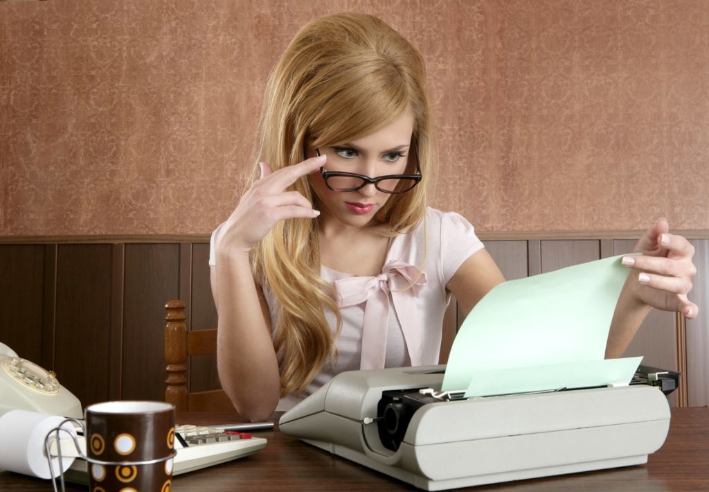 Frau mit Brille an einer Schreibmaschine